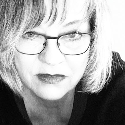 Schwarz-Weiß-Motiv von Karin Jesinghaus: Angeschnittenes Gesicht mit Bob-Haarschnitt und Brille blickt konzentriert frontal in die Kamera