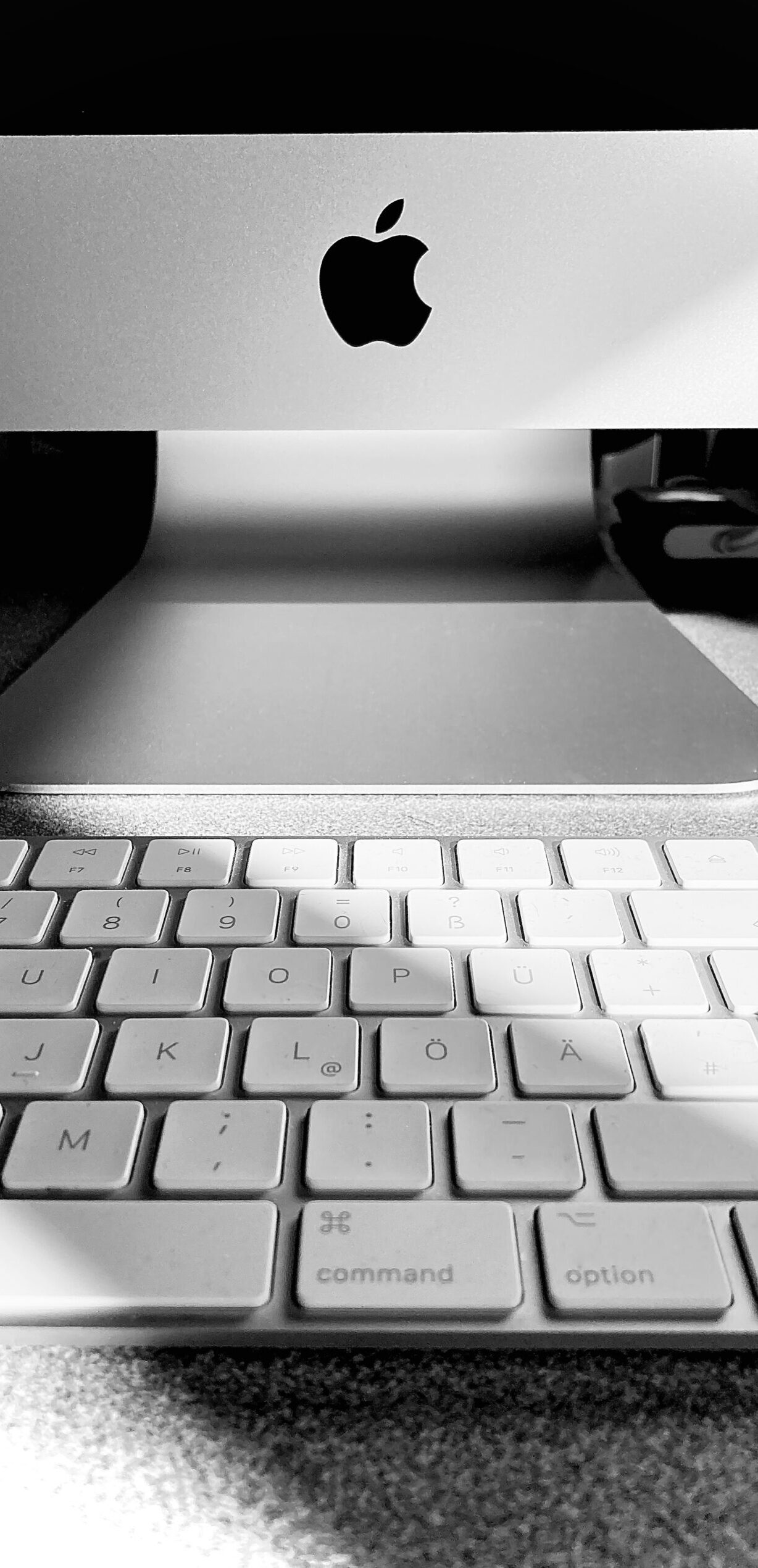 Schwarz-Weiß-Detailaufnahme eines Macintosh-Rechners mit Tastatur mit stimmungsvollem Licht-Schatten-Spiel